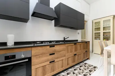 a kitchen with wooden cabinets and black appliances at Comfortable & Cozy by NDP rent in Rome