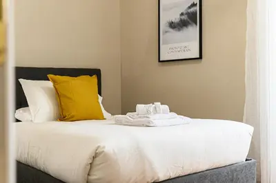 a bed with white sheets and yellow pillows at Comfortable & Cozy by NDP rent in Rome