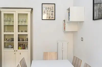 a dining room with a white table and a cabinet at Comfortable & Cozy by NDP rent in Rome