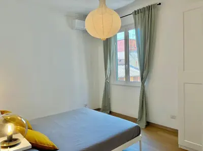 a bedroom with a bed with a lamp and a window at Roma San Pietro rooftop view in Rome