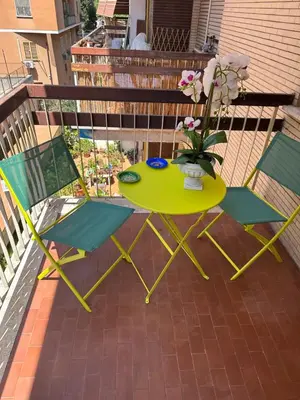 a table and two chairs and a vase with flowers on a balcony at Dany & Manu House in Rome