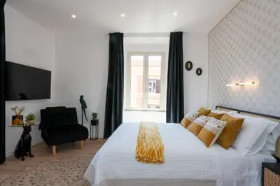 a bedroom with a large bed and a black chair at Sistine Chapel View Rooms Check-in From 3 Pm To 10 Pm in Rome