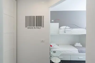 a white room with a bed and a shelf at Casa Volver in Rome