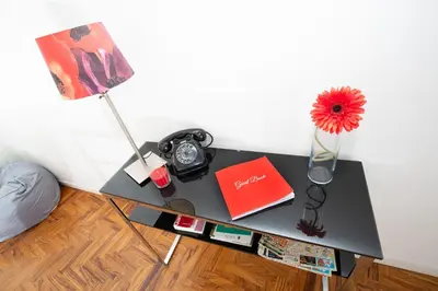 a table with a clock and a vase with a flower at Casa Volver in Rome