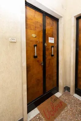a wooden door in a building with a sign on it at Casa Volver in Rome