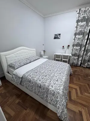 a white bedroom with a bed and wooden floors at Destination In Rome in Rome
