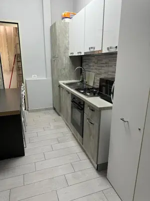 a kitchen with white cabinets and a stove top oven at Destination In Rome in Rome