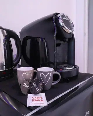 a coffee maker and two cups on a counter at Essenza House Piazza Fiume in Rome