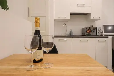 a bottle of wine sitting on a table with two wine glasses at Essenza House Piazza Fiume in Rome
