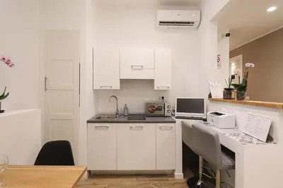 a kitchen with white cabinets and a counter top at Essenza House Piazza Fiume in Rome