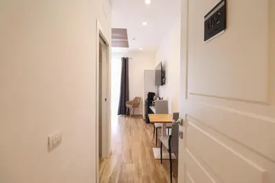 a hallway with a door and a room with a table at Essenza House Piazza Fiume in Rome