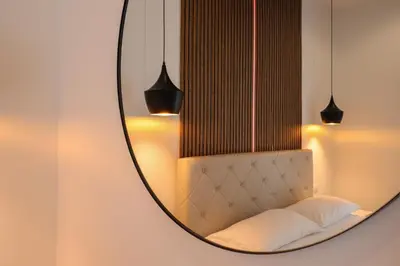 a mirror on a wall with a bed in a room at Essenza House Piazza Fiume in Rome
