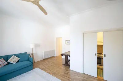 a living room with a blue couch and a table at Bright and Lovely Apartment in San Lorenzo in Rome