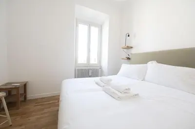 a white bed in a room with a window at Bright and Lovely Apartment in San Lorenzo in Rome