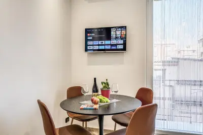 a dining room table with chairs and a tv on the wall at Appartamento Roma metro C Greghouse Centocelle in Rome