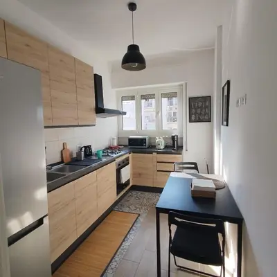 a kitchen with wooden cabinets and a blue table at Caravaggio Inn in Rome