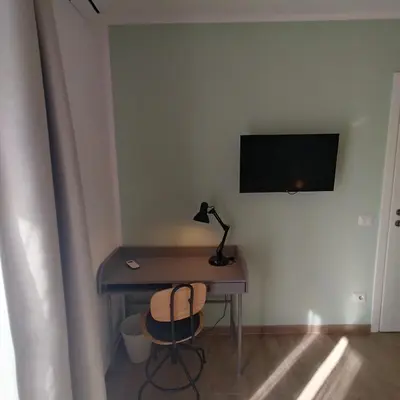 a table with a lamp and a desk with a monitor at Caravaggio Inn in Rome