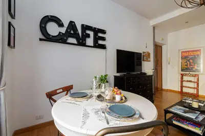 a dining room with a table with a cat sign on the wall at Beautiful Apartment Rome Vaticano in Rome