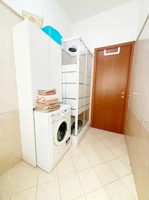a laundry room with a washing machine and a wooden door at PR - appartamento in centro a Roma in Rome