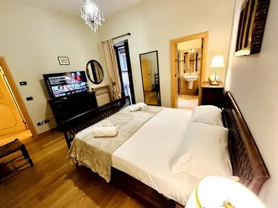 a bedroom with a large bed and a flat screen tv at Benedetta house Trastevere in Rome