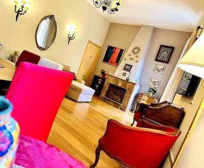 a living room with a red chair and a fireplace at Benedetta house Trastevere in Rome