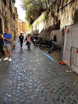 a group of people walking down a stone street at Benedetta house Trastevere in Rome