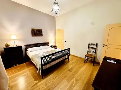 a bedroom with a large bed and a chandelier at Benedetta house Trastevere in Rome