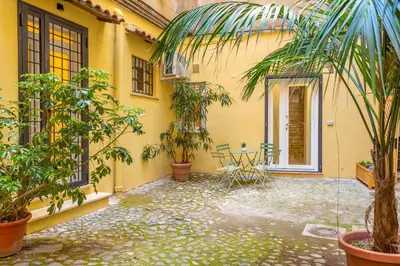a courtyard of a house with a table and plants at Pantheon Giovanni Hideaway in Rome