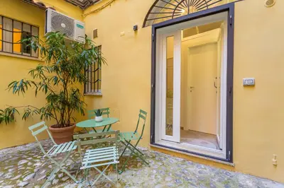 a patio with a table and chairs next to a building at Pantheon Giovanni Hideaway in Rome
