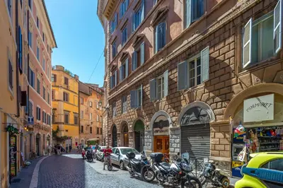 a narrow street with motorcycles parked on the side of buildings at Pantheon Giovanni Hideaway in Rome