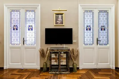 a living room with two white doors and a television at AMOE - Eleganza e Storia nel Cuore di Roma in Rome