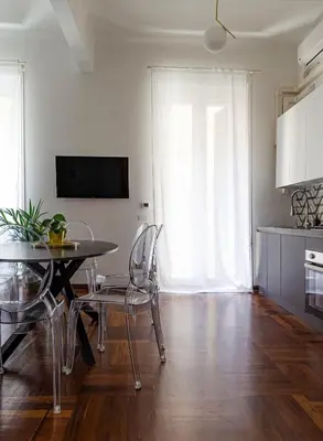 a living room with a table and chairs and a kitchen at AMOE - Eleganza e Storia nel Cuore di Roma in Rome