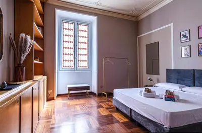 a bedroom with a large bed and a window at AMOE - Eleganza e Storia nel Cuore di Roma in Rome