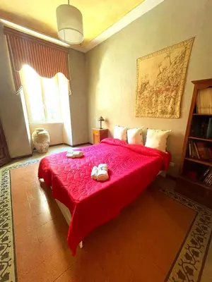 a bedroom with a red bed with two stuffed animals on it at Vatican Mamma Roma in Rome