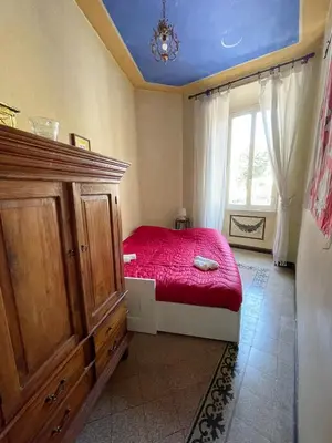 a bedroom with a red bed and a window at Vatican Mamma Roma in Rome