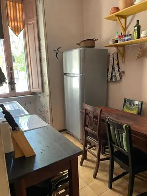 a kitchen with a table and a refrigerator at Vatican Mamma Roma in Rome