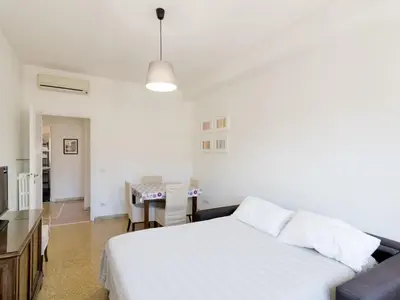 a white bedroom with a bed and a table at Apartment Appartamento Renato Roma Musei Vaticani by Interhome in Rome