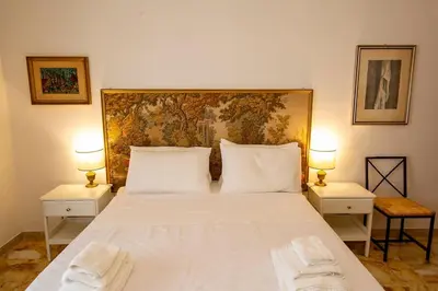 a bedroom with a large white bed with two lamps at Dimora al Colosseo, 2 bedrooms in Rome