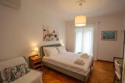 a bedroom with a bed and a chair in it at Dimora al Colosseo, 2 bedrooms in Rome