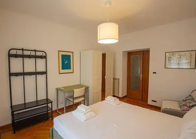 a bedroom with two beds and a desk in it at Dimora al Colosseo, 2 bedrooms in Rome