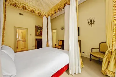 a bedroom with a canopy bed and two chairs at YCH-Magnifica residenza a Campo de Fiori in Rome