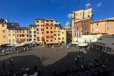 a group of people walking around a city with buildings at YCH-Magnifica residenza a Campo de Fiori in Rome