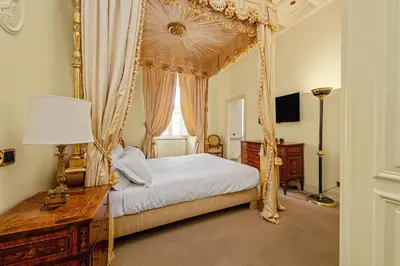 a bedroom with a canopy bed with a desk and a window at YCH-Magnifica residenza a Campo de Fiori in Rome