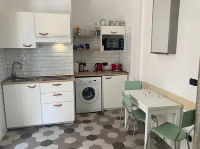 a kitchen with a table and a washing machine at Garbatella Garden Home in Rome