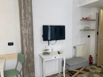a room with a table and a tv on a wall at Garbatella Garden Home in Rome