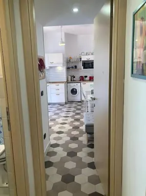 a kitchen with a checkered floor and white cabinets at Garbatella Garden Home in Rome