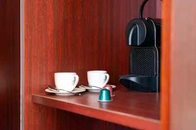 two coffee cups and saucers on a wooden shelf at The Couper Umiltà in Rome