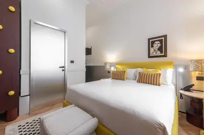 a bedroom with a large white bed and a desk at The Couper Umiltà in Rome
