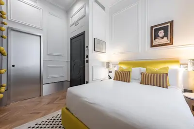 a bedroom with a large white bed and a door at The Couper Umiltà in Rome