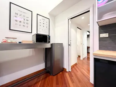 a room with a counter with a microwave and a hallway at Trastevere Wondersuite in Rome